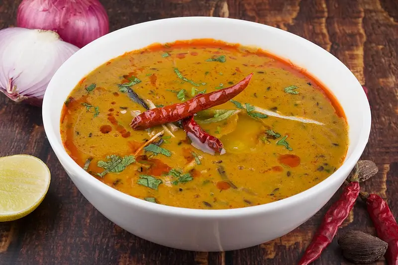 Bowl of yellow dal tadka with dried red chillies