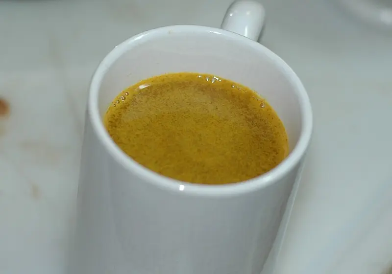 White mug of golden turmeric tea